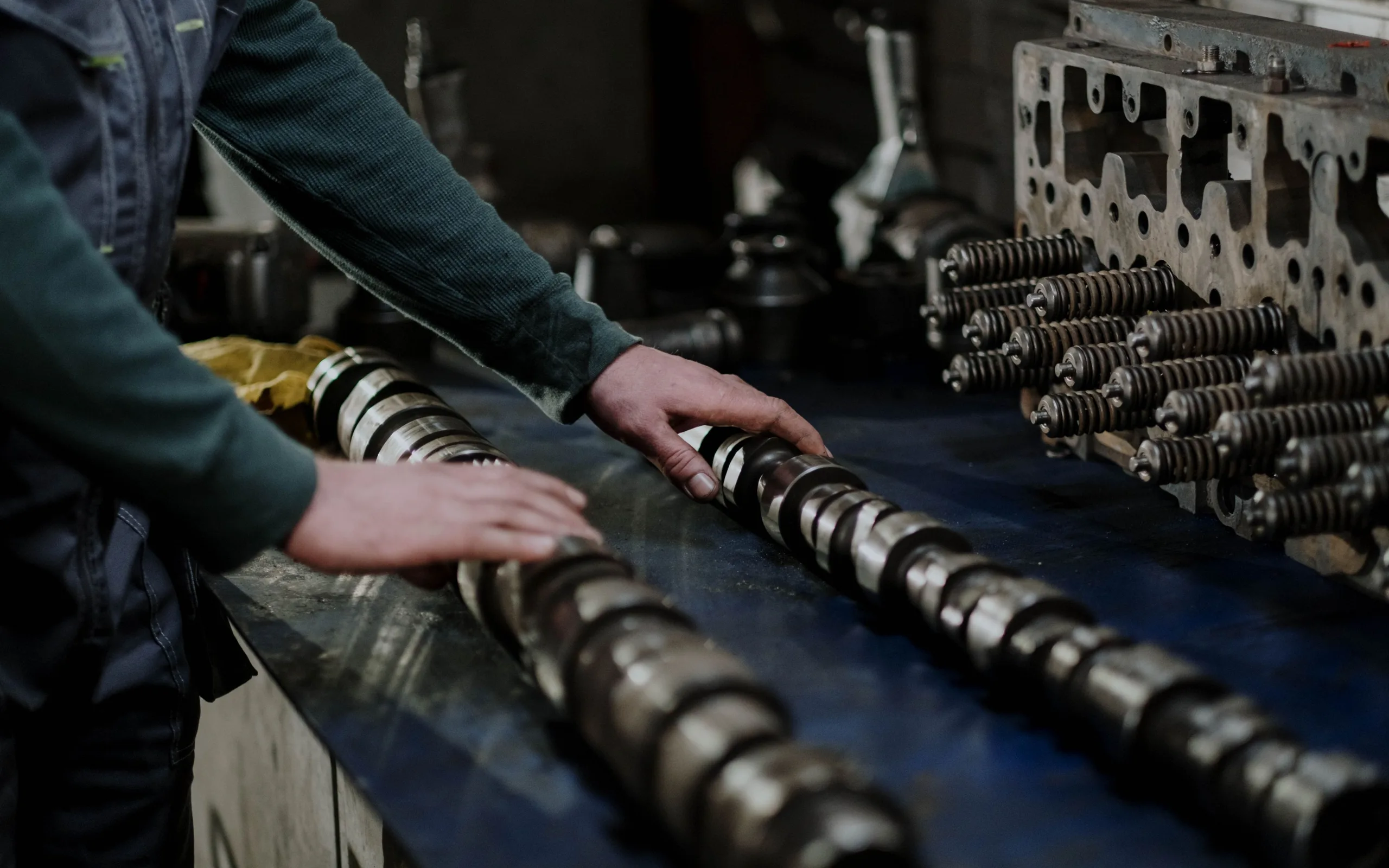Mécanicien travaillant les arbres à cames et la culasse d’un moteur dans un atelier